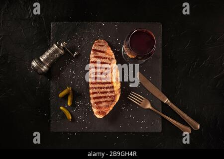Grilled beef steak with red wine, shot from the top on a black background Stock Photo