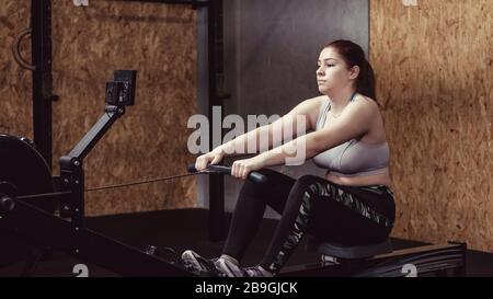 Young woman working out doing resistance pulls Stock Photo