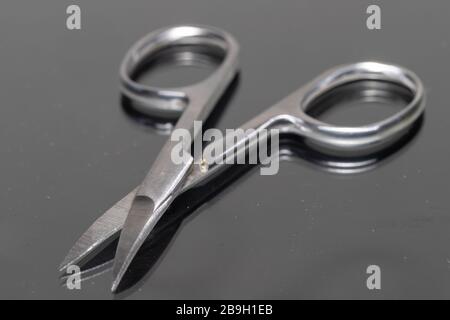 Close-up of open manicure scissors with a reflection. Stock Photo