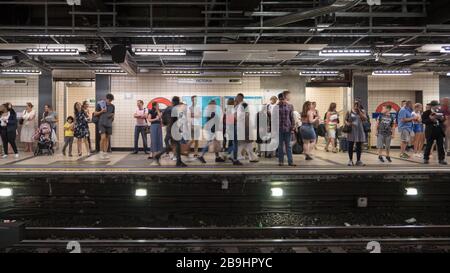 Victoria Underground tube station platform. Travellers standing waiting for trains on the west bound Circle and District lines. Stock Photo