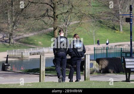 Police officers walk through Mote Park in Maidstone, Kent, the day after Prime Minister Boris Johnson put the UK in lockdown to help curb the spread of the coronavirus. Stock Photo