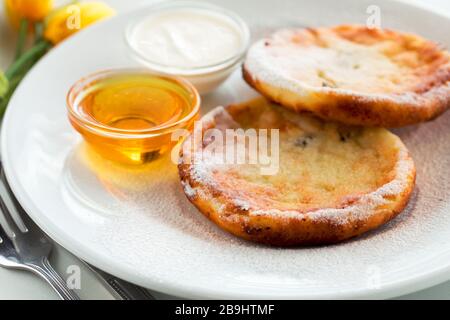 Cottage cheese fritters or pancakes with honey ukrainian cuisine. Breakfast cheesecake Stock Photo