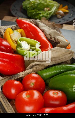 Tomato and peppers in a wooden container. Stock Photo