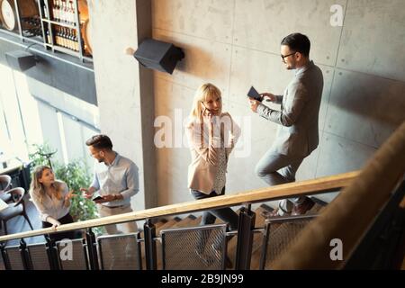 Group of businesspeople walking and taking stairs in an office building Stock Photo
