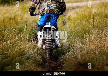 back driver on motorcycle enduro riding on a forest trail Stock Photo