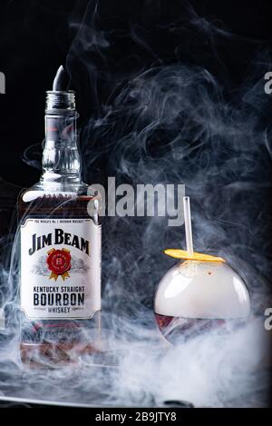 Odessa, Ukraine - February 07, 2020: Jim Beam is one of best selling brands of bourbon. Alcohol with smoke. Jim Beam bottle arranged with a spherical Stock Photo