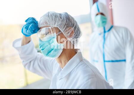 Stress and strain on doctors and nurses in clinic due to coronavirus pandemic Stock Photo