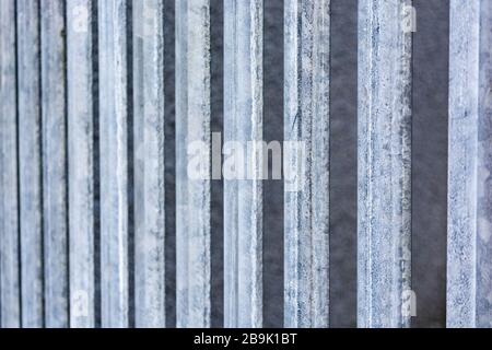 Row of galvanized steel fencing posts in sunshine. For US-Mexico border wall, restricted movement, look beyond, physical barrier, imprisoned, lockdown Stock Photo