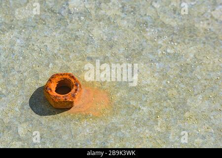 Close-up shot of rust encrusted / rusty steel bolt on galvanized steel metal in sunshine. Shallow DoF. For metal abstract, metal oxidation, rusting. Stock Photo