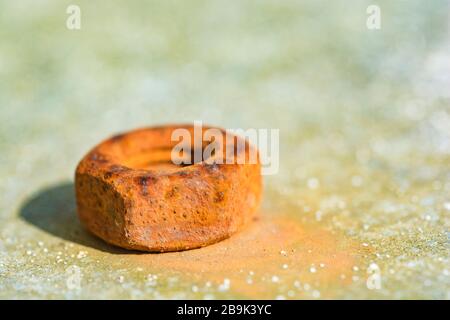 Close-up shot of rust encrusted / rusty steel bolt on galvanized steel metal in sunshine. Shallow DoF. For metal abstract, metal oxidation, rusting. Stock Photo