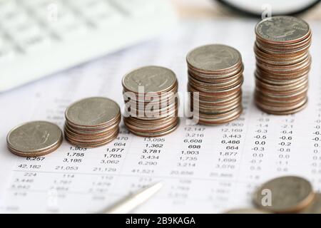 Row of silver coins standing at financial report paper Stock Photo