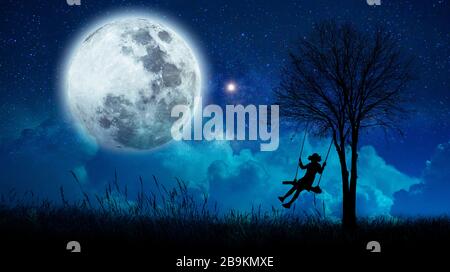 imagination The girls are cradling amidst many stars and full moon at night. Stock Photo
