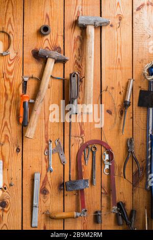 Carpentry tools hanging on the wooden wall Stock Photo