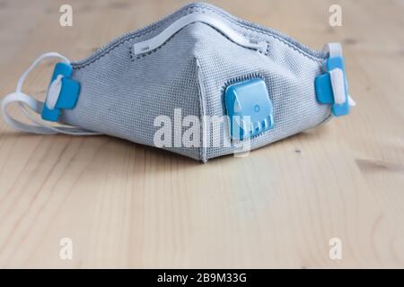 Respirator face mask with heavy-duty protective filter on a wooden light background. Madical face mask. Copy space. Stock Photo