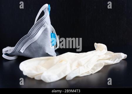 Respirator face mask with heavy-duty protective filter and latex gloves on a wooden light background. Madical face mask. Stock Photo