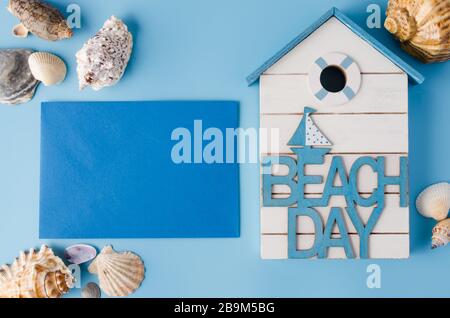 Different seashells and inscription beach day on blue. Summer background. Stock Photo