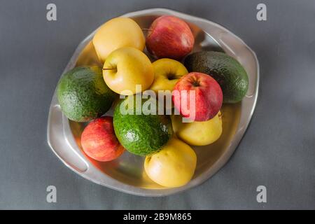 Colorful multivitaminic fruits on the steel tray on grey background. Top view. Stock Photo