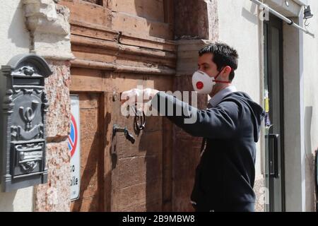 Pergine Valsugana, Italy. 24th Mar 2020. Most part of Europe is today on a sweeping confinement to try to slow down the spread of the Covid-19 Pandemic. A man wearing mask and gloves get inside his home. (Photo by Pierre Teyssot/ESPA-Images) Credit: European Sports Photographic Agency/Alamy Live News Stock Photo