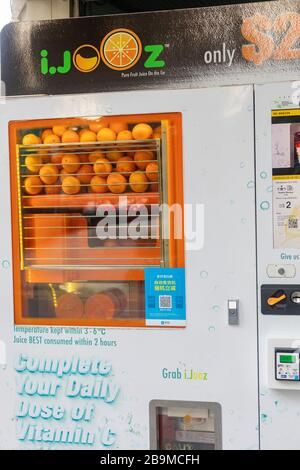 Freshly squeezed orange juice vending machine in Singapore Stock Photo