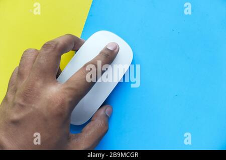 man hand use computer muse on color background. Stock Photo