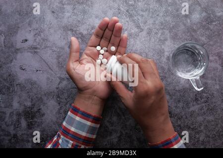 top view of man's hand taking pills from container  Stock Photo