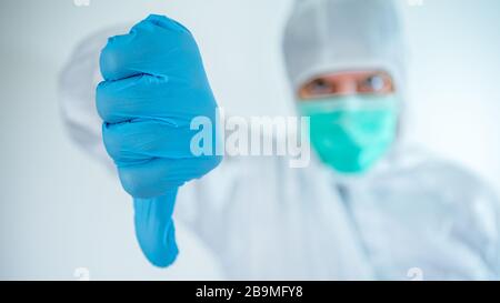 Male doctor hand pointing. Caucasian man in a protective suit and mask giving thumb down mean result are bad. Medical and health care concept, Biologi Stock Photo