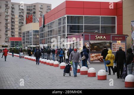 Bucharest, Romania - March 24, 2020: Shoppers stand in a queue outside a supermarket, after a Coronavirus lockdown is announced. Stock Photo