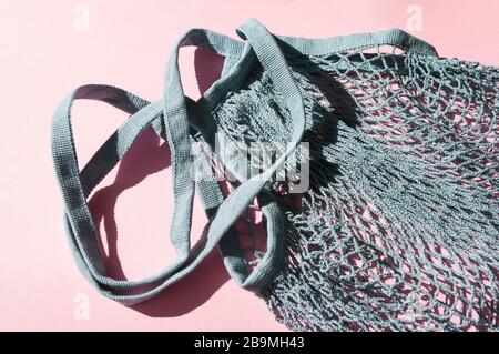 Blue cotton string knitted bag on pink background. Top view, flat lay. Zero waste, eco friendly shopping Stock Photo