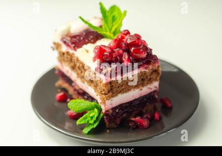Colorful multi-layered cream chocolate cake with cherry jam and pomegranate, a delicious treat Stock Photo