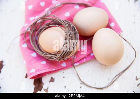 three eggs on the table on a rose napkin. Stock Photo