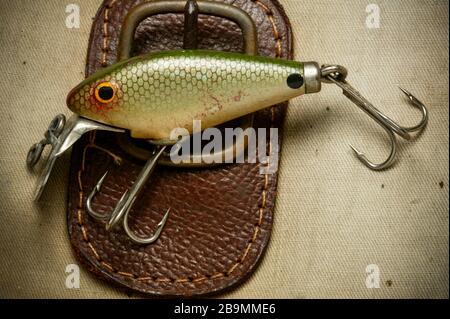 https://l450v.alamy.com/450v/2b9mme6/an-example-of-a-vintage-fishing-lure-equipped-with-treble-hooks-possibly-made-by-woods-mfg-displayed-on-an-old-fishing-bag-lures-such-as-these-are-2b9mme6.jpg