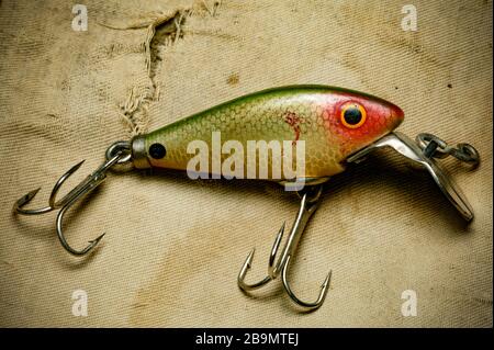An example of a vintage fishing lure equipped with treble hooks, possibly  made by Woods Mfg, displayed on an old fishing bag. Lures such as these are  Stock Photo - Alamy