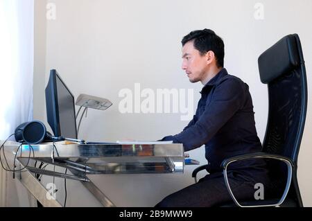 A man working from home at a desk Stock Photo