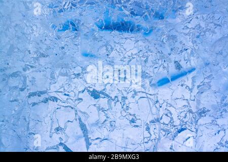 Texture of transparent clear ice with cracks and scratches. Blue Ice with intricate pattern. Horizontal. Stock Photo