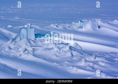 Carved large pieces of ice in snow hummocks on Lake Baikal. Winter landscape. The ice is covered with snow. Horizontal. Stock Photo