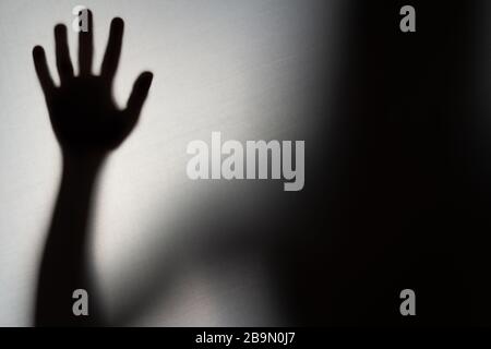 Blurred Woman's hand shadow asking for help. Horror and domestic violence concept Stock Photo