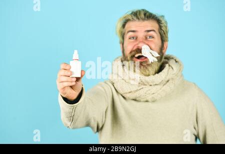 man use nasal drops during course of disease. happy man says no to flu. coronavirus from china. immune system help during epidemic. healthcare in winter. best cold remedy. helpful nasal spray. Stock Photo