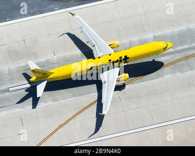 Aerial view of Spirit Airlines Airbus A321 departing Los Angeles International Airport. High view of yellow airplane taking off. N657NK registered. Stock Photo