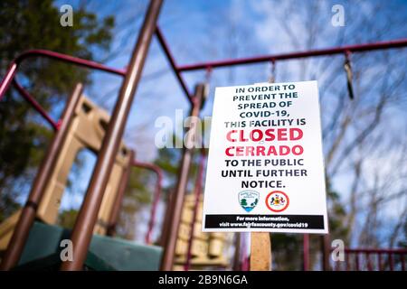 Herndon, USA - March 24, 2020: Sign in children's playground in Virginia city for park closure, facility closed to public due to covid-19 to stop spre Stock Photo