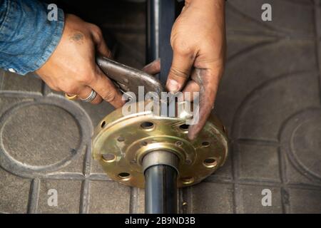 Man Man tightens the nut with a wrench, assembling detail of the system rolling gate. Stock Photo