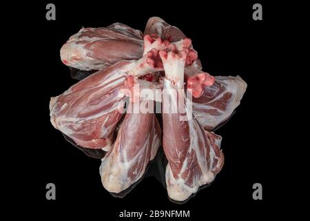 Raw lamb shank on black background. Top view. Space for text. Stock Photo
