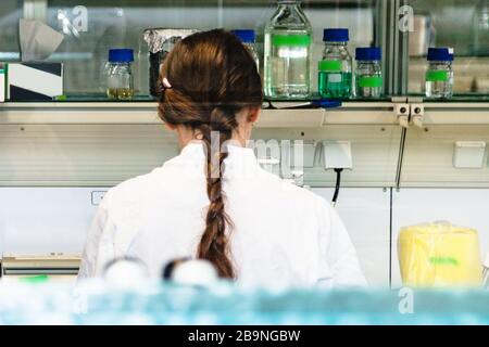 Close up of back of female scientist in laboratory Stock Photo
