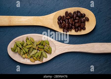 Coffee and cardamom on wooden spoons. Stone background Stock Photo