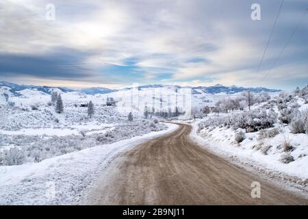 Old Dirt Road in a Barren Mountainous Winter Wonderland: Snow-covered Countryside of the Methow Valley after Sunset - Washington, USA Stock Photo
