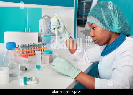 Female African medical students, young graduates in research laboratory or medical test lab perform tests for presence of viral rna in samples. Pcr nu Stock Photo