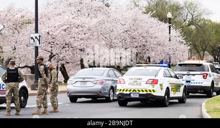 Security officers at Washington DC Tidal Basin during Cherry Blossom.The Metropolitan Police Department, supplemented by some members of Washington DC National Guard, set up a perimeter around the Tidal Basin to enforce social distancing by keeping people away from the trees so that people would not crowd there as they have in previous days. Stock Photo