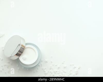 Natural cream bottle with mirrory cover top cap and marine sea salt isolated on white background with copy space. Flat lay, top view from above, minim Stock Photo