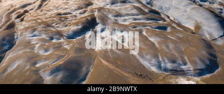 aerial landscape showing badland in the Tian Shan mountains arounf the amazing Ozero Torpo, a lake surrounded by eroded mud hills along the Mels-Ashu Stock Photo