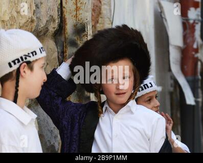 A young Hassidic Jewish boy dressed as an older Hassidic Jewish man for the Purim festival in Mea Shearim neighborhood in Jerusalem. Stock Photo