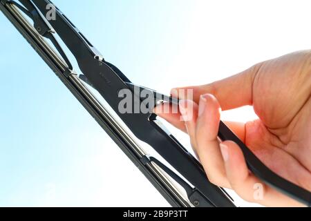 Hand holding a car's side lock windshield wiper. Changing vehicle's wiper Stock Photo